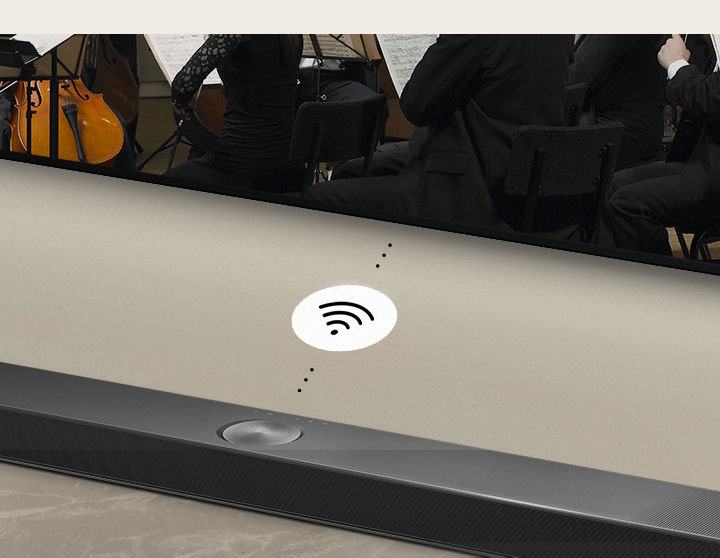 Zbliżenie na LG Soundbar umieszczony pod LG TV. Symbol łączności pomiędzy LG Soundbar i LG TV wskazuje na bezprzewodowe działanie WOWCAST.