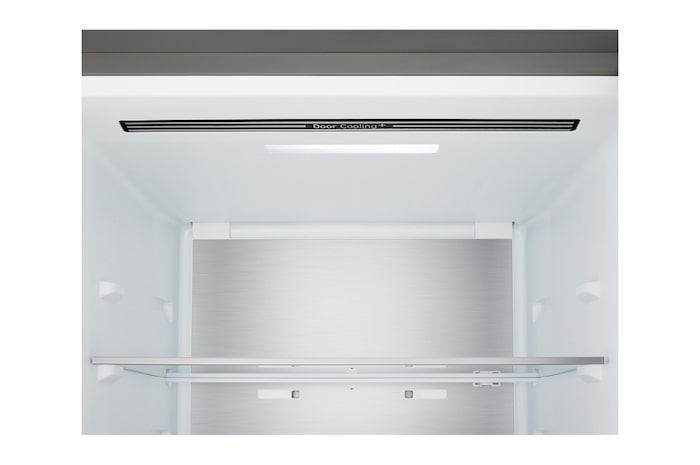 Lodówka z dolną zamrażarką LG (GBBS726CEV) w przestrzeni mieszkalnej z widokiem na miasto nocą; na zdjęcie nałożono grafikę przedstawiającą tryb oszczędzania energii AI oraz wykres zmiennego zużycia energii