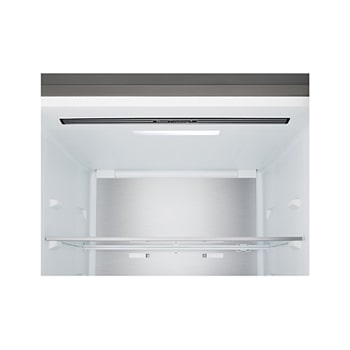 Lodówka z dolną zamrażarką LG (GBBS726CEV) w przestrzeni mieszkalnej z widokiem na miasto nocą; na zdjęcie nałożono grafikę przedstawiającą tryb oszczędzania energii AI oraz wykres zmiennego zużycia energii