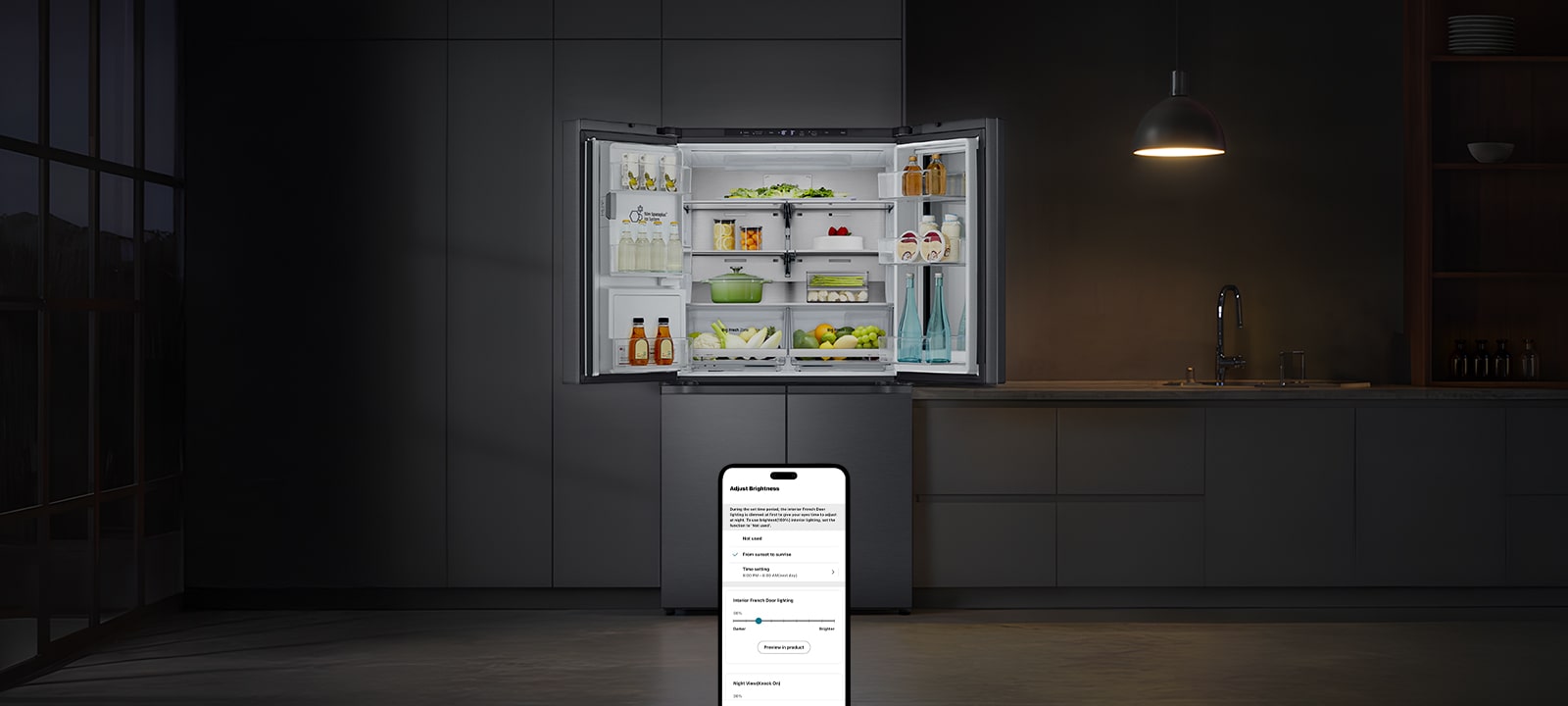 Ciemna kuchnia z wiszącą lampą nad otwartą lodówką LG, w której widoczne jest uporządkowane jedzenie	