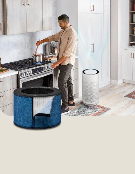 Purificador de aire LG con filtro para cocinar funcionando en segundo plano mientras un hombre cocina en la cocina.	
