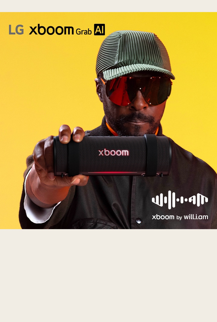 will.i.am, vestido de negro y con lentes de sol, sostiene la xboom Grab en primer plano.