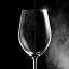 Um copo de vinho com manchas de água de um lado e cristalino do outro, mostrando a diferença após a lavagem a vapor.