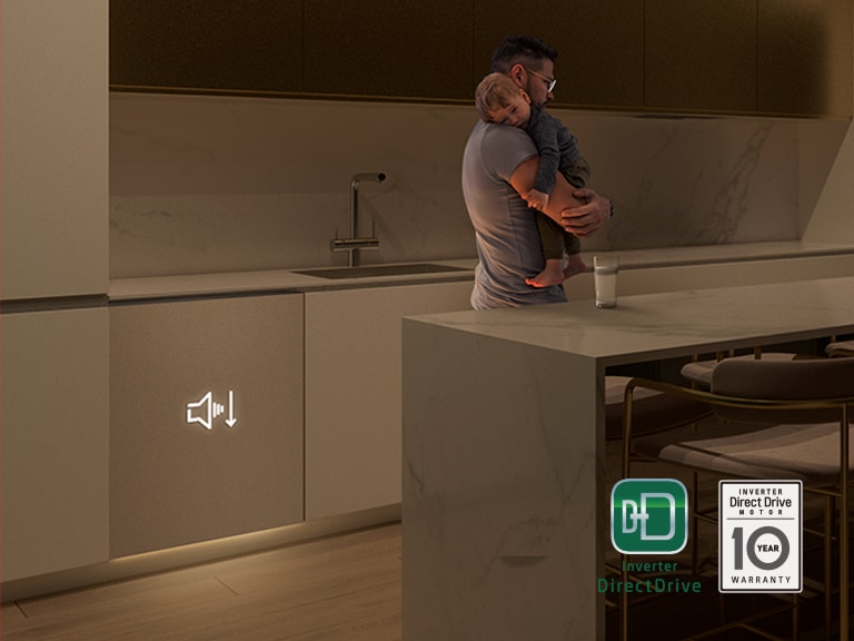 Um homem tem um bebé a dormir ao colo numa cozinha com pouca luz. A máquina de lavar loiça LG funciona silenciosamente em segundo plano para um funcionamento tranquilo.