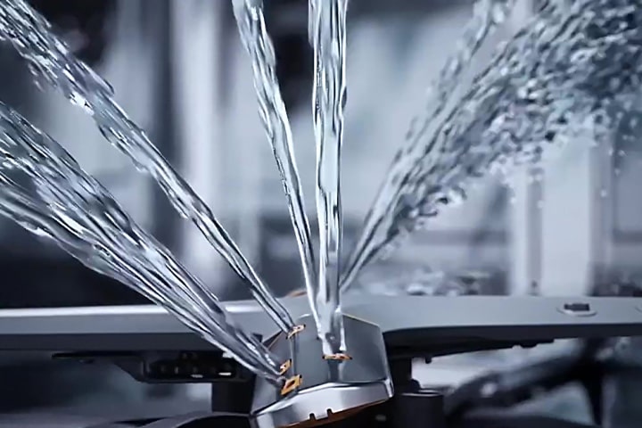 Imagem aproximada de jatos de água intensos a serem dispersos pelos braços rotativos, dentro de uma máquina de lavar loiça LG, mostrando o poder da ação de limpeza.