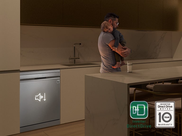 Homem a segurar um bébé numa cozinha escura. A máquina de lavar loiça LG está a funcionar silenciosamente em fundo, para uma operação silenciosa.