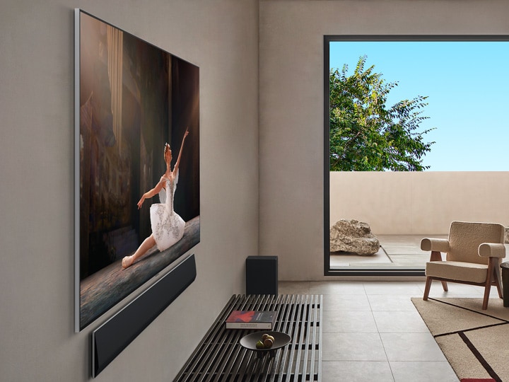 Sala de estar no interior de uma casa de luxo. Vista lateral em ângulo de uma LG OLED TV montada na parede. Pode ver-se que não existe qualquer espaço entre o televisor e a parede.