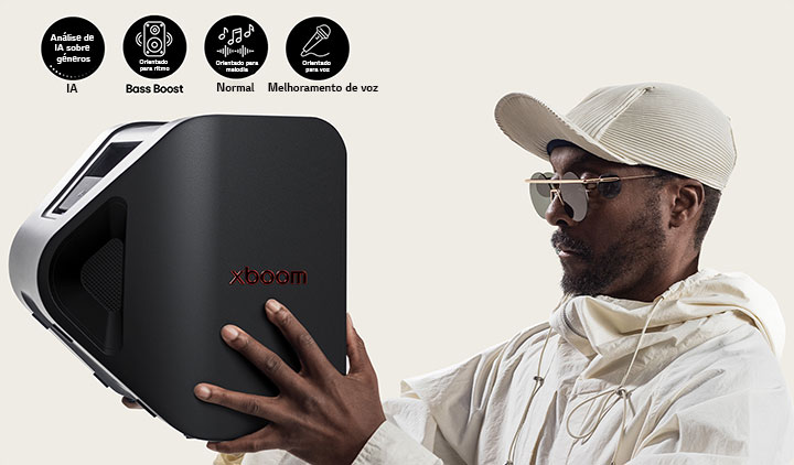 will.i.am em roupa branca e boné branco está a segurar o xboom Stage 301 com os dois braços, junto ao rosto.