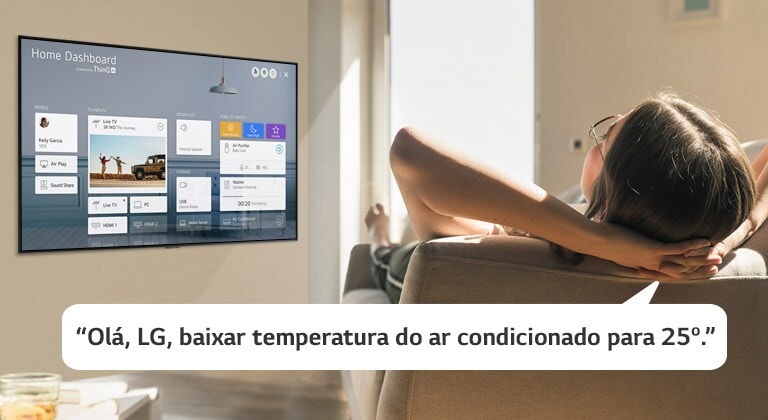 Mulher deitada no sofá a dizer à televisão para baixar a temperatura com o Home Dashboard no ecrã de televisão