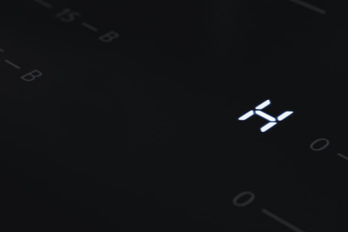 Imagem próxima da luz LED "H", que é um indicador de calor na placa de indução.