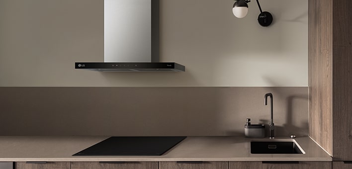 Imagem de uma placa de indução LG e exaustor instalados na cozinha.