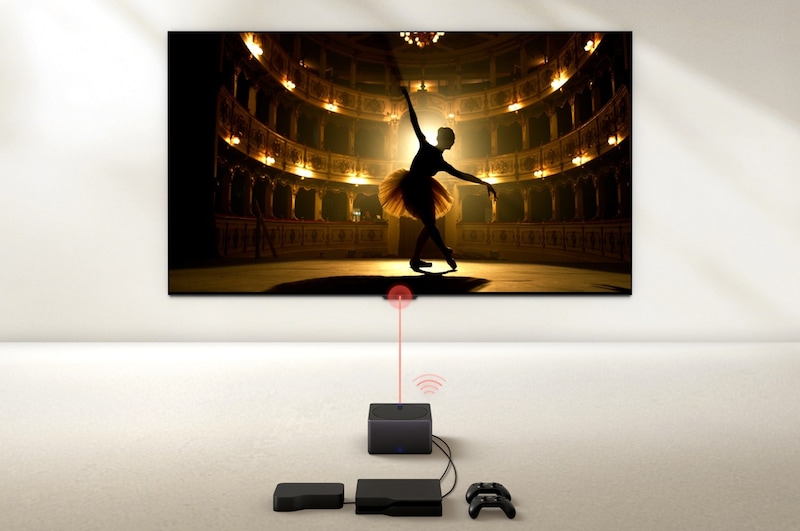 Uma Zero Connect Box em frente a uma LG OLED evo M4, com um sinal Wi-Fi vermelho e um feixe vermelho a emitir em direção à TV. A TV mostra uma bailarina a dançar a solo no palco.