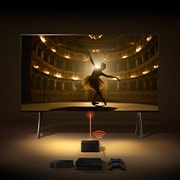 Uma Zero Connect Box em frente a um LG SIGNATURE OLED M4, com um sinal Wi-Fi vermelho e um feixe vermelho a emitir em direção à TV. A TV mostra uma bailarina a dançar a solo no palco.