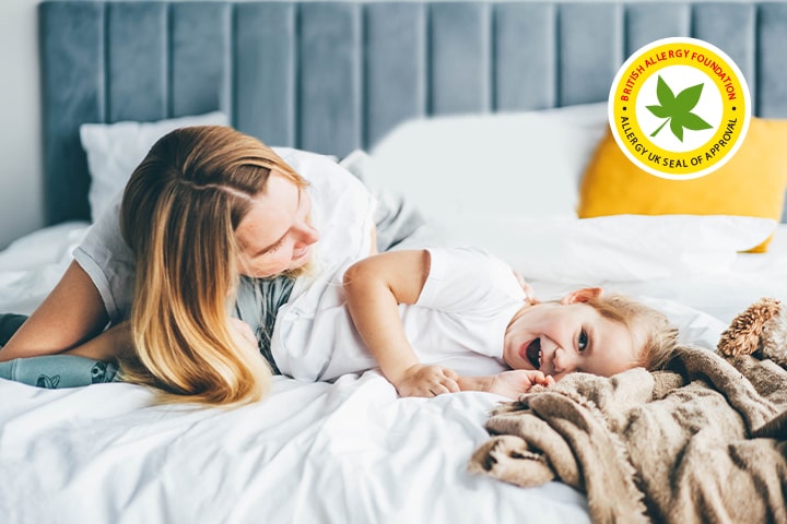 A criança e a mãe estão deitadas na cama.