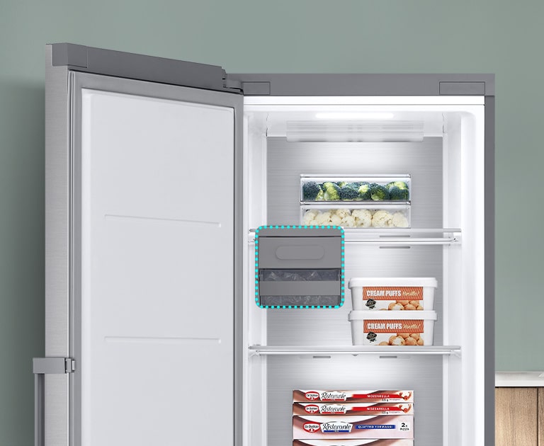 O congelador está aberto com itens nas várias prateleiras. Uma linha azul realça o lugar o Ice Maker e demonstra que este pode ser removido para espaço de armazenamento extra.