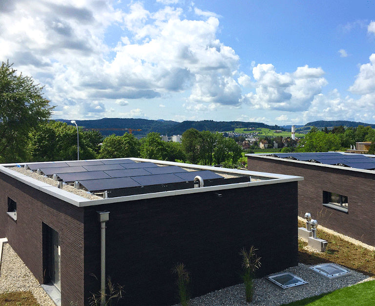 Módulo LG NeON 2 Black instalado numa cobertura plana num pequeno edifício habitacional.
