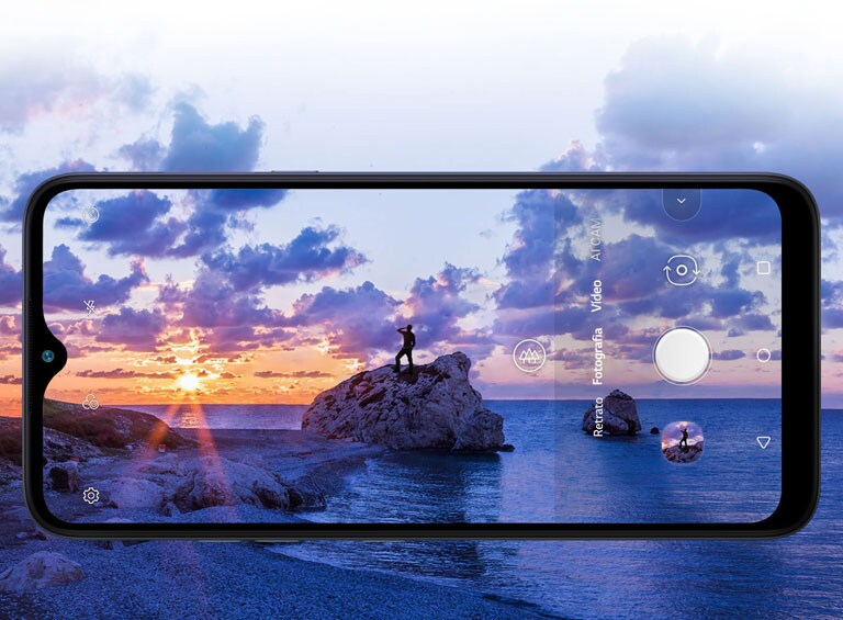 Smartphone a fotografar um homem a observar a praia ao pôr do sol.