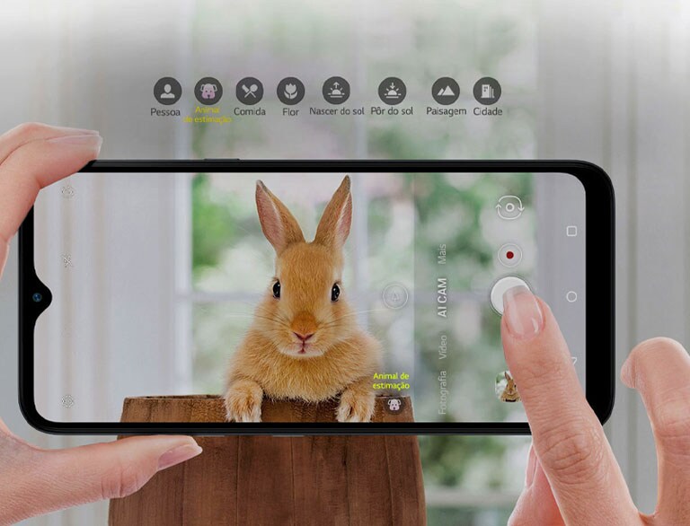 Vista ampliada de alguém a segurar um smartphone e a fotografar um coelho