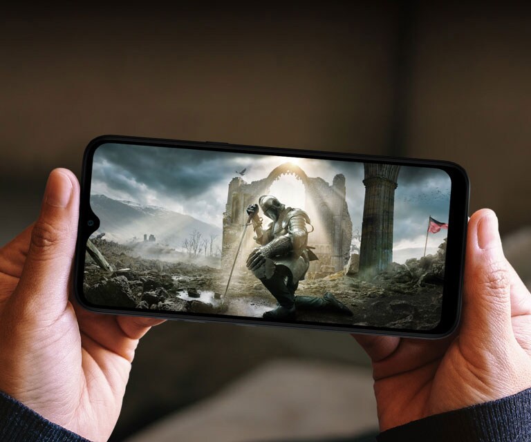 Mulher a segurar um smartphone com ambas as mãos e a ver um filme medieval