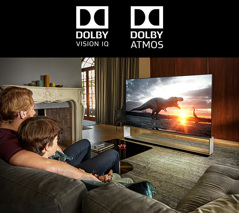 A marca do DOLBY VISION IQ / A marca do DOLBY ATMOS, Pai e filho a assistirem a um documentário sobre dinossauros numa TV de ecrã grande