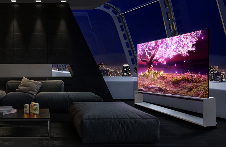 Uma TV num suporte com uma árvore que emite luz cor-de-rosa num casa de ambiente escuro e moderno