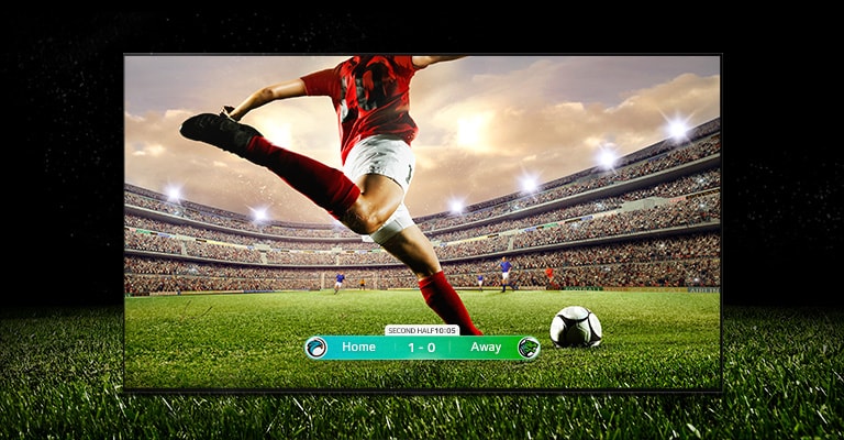 Imagem de um ecrã com um jogo de futebol e um jogador numa faixa vermelha prestes a pontapear a bola para o outro lado do estádio. O resultado do jogo é visível no fundo do ecrã. A relva verde do campo vai além do ecrã para um fundo preto.