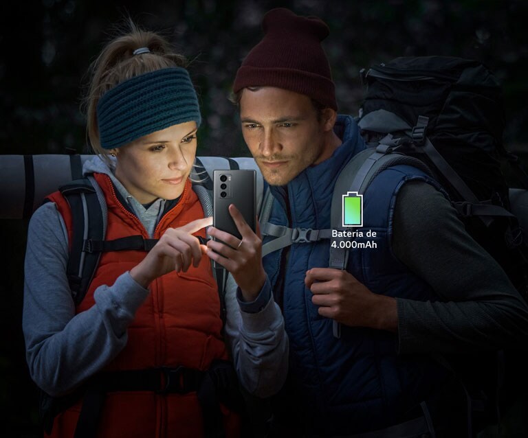 Casal a ver o ecrã de um smartphone enquanto escala à noite.
