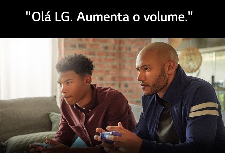 Dois homens num sofá a segurarem comandos de jogo sem fios, embrenhados num jogo