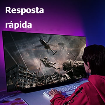 Uma rapariga joga um jogo de computador numa TV de grande ecrã onde um soldado desce de um helicóptero.