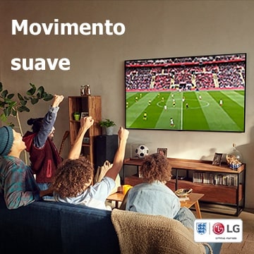 Quatro pessoas sentadas num sofá a assistir a um jogo de futebol numa sala.