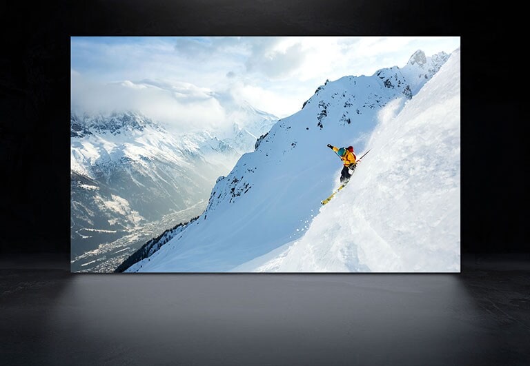 Um ecrã de TV com uma imagem de um homem a fazer esqui em montanhas cobertas de neve tanto numa LG OLED como numa LG OLED evo para expressar a diferença de luminosidade e nitidez da imagem. (reproduzir o vídeo)