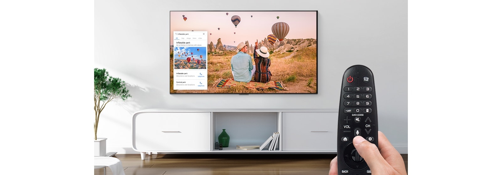 Vista ampliada de uma mão a controlar a TV com um controlo remoto para perguntar qual é o local apresentado na TV.