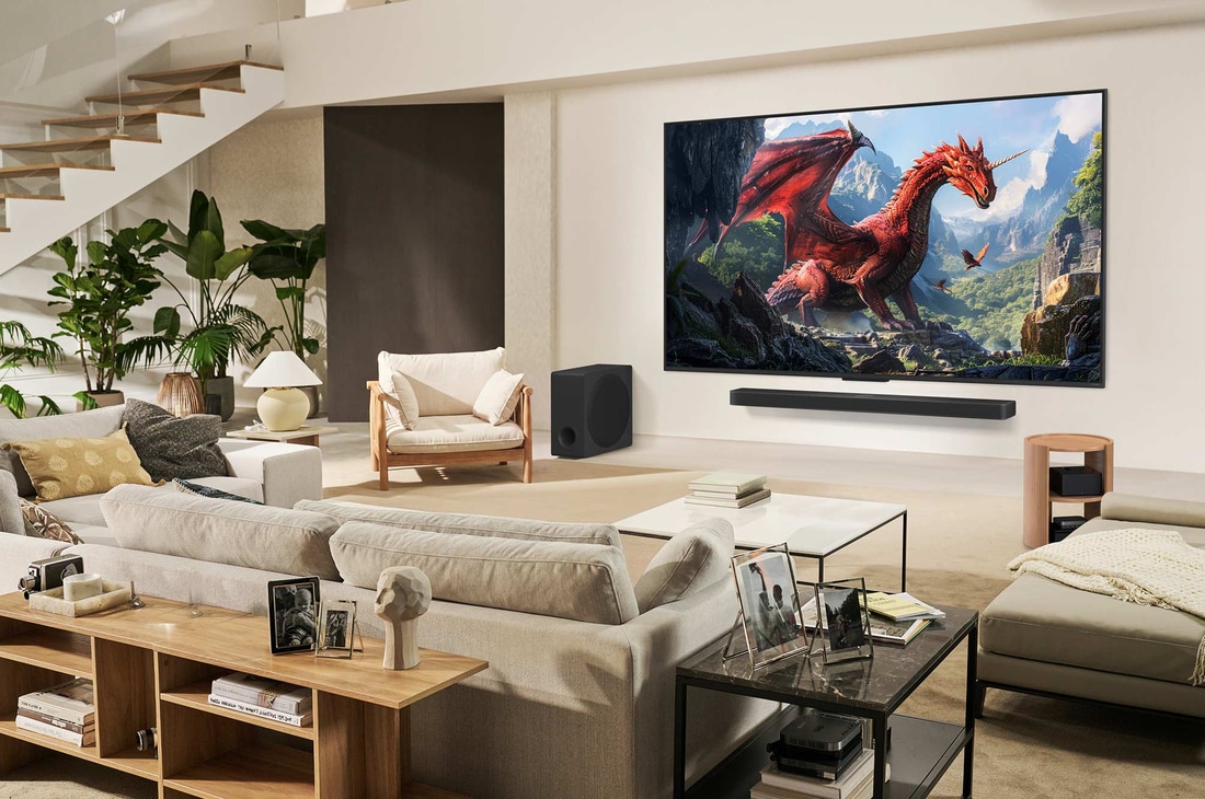 A family sits on a couch facing a LG QNED TV mounted on a wall above a LG Soundbar. Zero Connect Box sits inside a coffee table.