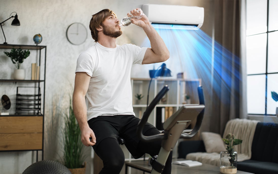 هذا فيديو لتيار هواء المُكيف يخرج خلف رجل يجلس على آلة التمرين وهو يشرب الماء.