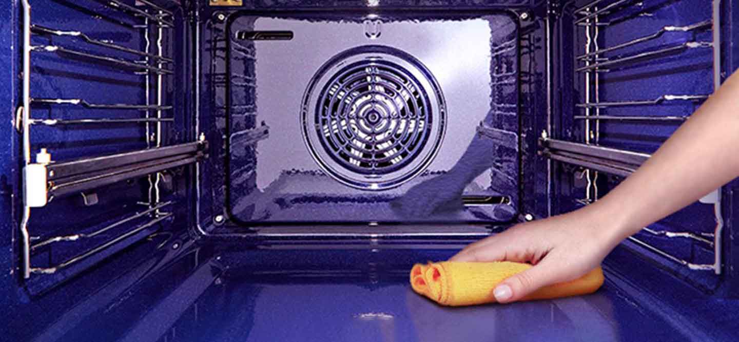 صورة مسح الفرن من الداخل بقطعة قماش.