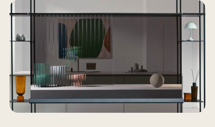تعرض شاشة LG SIGNATURE OLED T قطة تقفز عبر الشاشة الشفافة حيث تعرض المساحة الداخلية خلفها في نفس الوقت. تُوضَع الأشياء على الملحق الأيمن والأيسر للرف المعياري. يُوضَع تلفزيون شفاف آخر على النافذة التي تُؤطّر مشهد الشتاء خارج المنزل. تظهر على الشاشة بتلات الزهور المتساقطة. بالعودة إلى شاشة LG SIGNATURE OLED T في المشهد الأول، تعرض الشاشة الآن ثلاثة أشياء فخارية تنتقل من الخطوط الضبابية إلى الجسم الصلب.