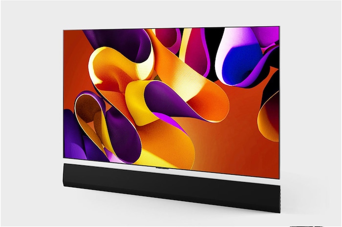 صورة جانبية مائلة بزاوية لليسار لتلفزيون LG OLED evo TV،‏ OLED G4 على الحائط مع مكبر الصوت Soundbar بالأسفل