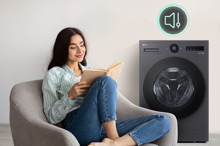 The woman is sitting on the sofa reading a book and showing a washing machine and a silent icon behind it