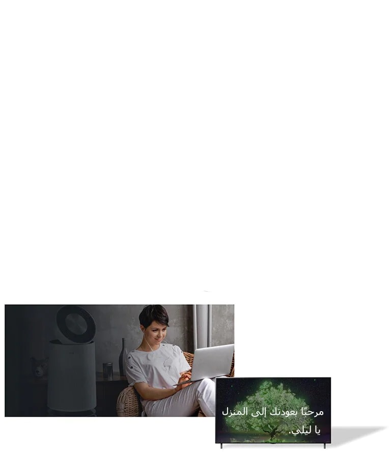 صورة تعرض امرأة جالسة على كرسي بالمنزل وتكتب على جهاز كمبيوتر محمول. هناك جهاز تنقية هواء خلفها. وهناك أيضًا تلفزيون بشاشة مسطحة بجانيها تعرض شاشته عبارة «مرحبًا بعودتك إلى المنزل يا ليلي.»