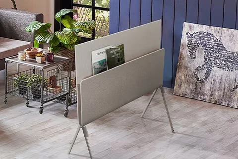 Posé seen from the back with nature magazines placed on the media shelf in a plant-themed living room.