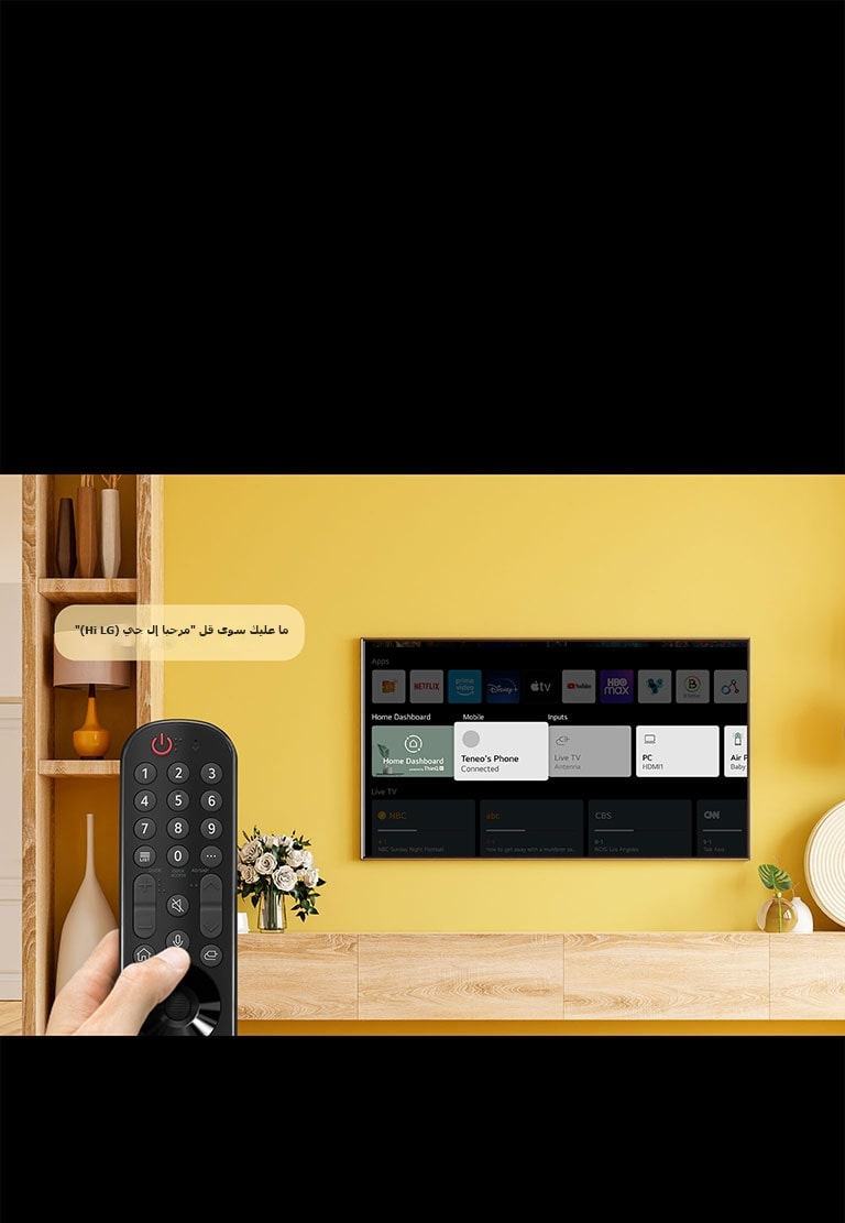 شخص ما يحمل جهاز التحكم عن بُعد الخاص بالتلفزيون أمام شاشة التلفزيون. وتظهر فقاعة حديث بها عبارة &quot;فقط قل مرحبًا إل جي (Just say Hi LG)&quot;.