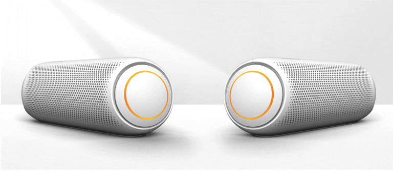 On a white background, two XBOOM Go's point to each other. They both have orange lighting.