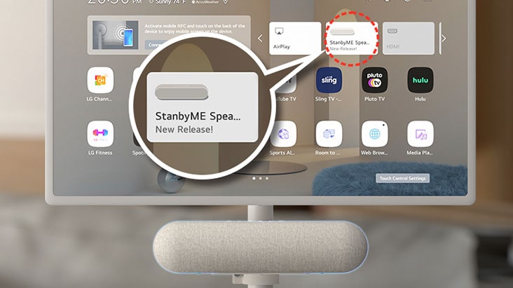 Close-up of the LG StanbyME screen. The XT7S speaker is attached at the bottom. The screen shows a home screen with the speaker's exclusive widget highlighted. To highlight the app, an enlarged image of the StanbyME speaker widget is also shown.