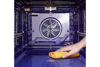 The image of wiping the inside of the oven with a cloth.