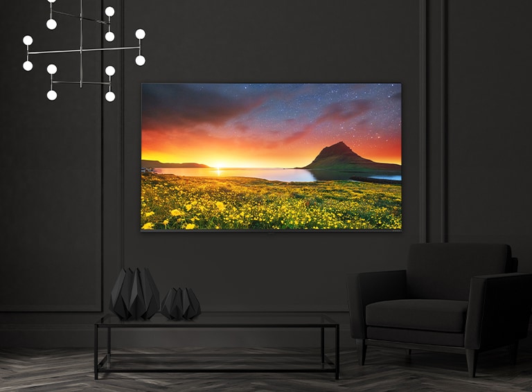 A TV hanging on the hotel wall shows a vivid and bright screen.