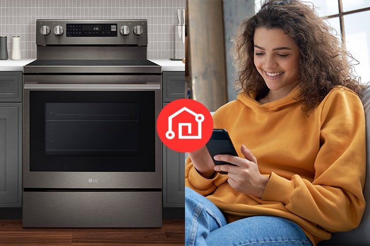 A woman using a smartphone next to an LG stainless steel electric range with a smart home icon overlay.