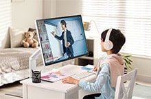 A child is watching an online class on a LG Smart Monitor Swing in a room.