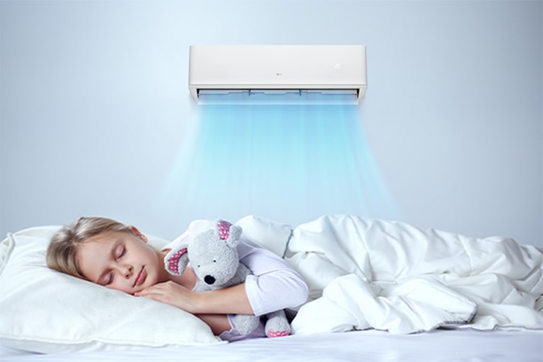 The air conditioner is operating. Below it, a girl is sleeping comfortably holding a doll.