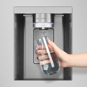 A person is getting a cup of water from lg multi door refrigerator's water dispenser.