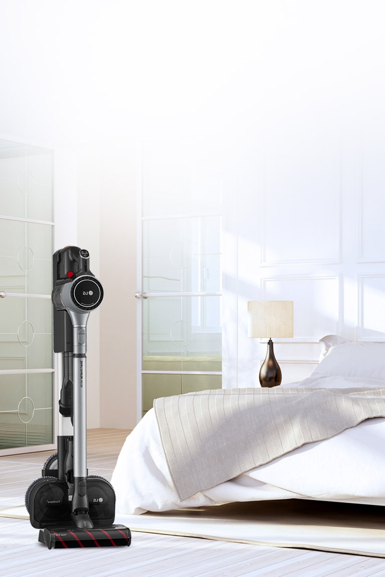 Three images show the vacuum cleaner in the charging stand in various locations: the first has the charging stand next to a couch, the second it is next to a desk, and the third it is next to a bed.